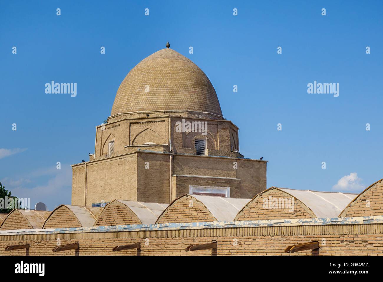 View of the Rukhabad mausoleum over the roofs of the cells of the madrasah of the same name. Shot in Samarkand, Uzbekistan Stock Photo