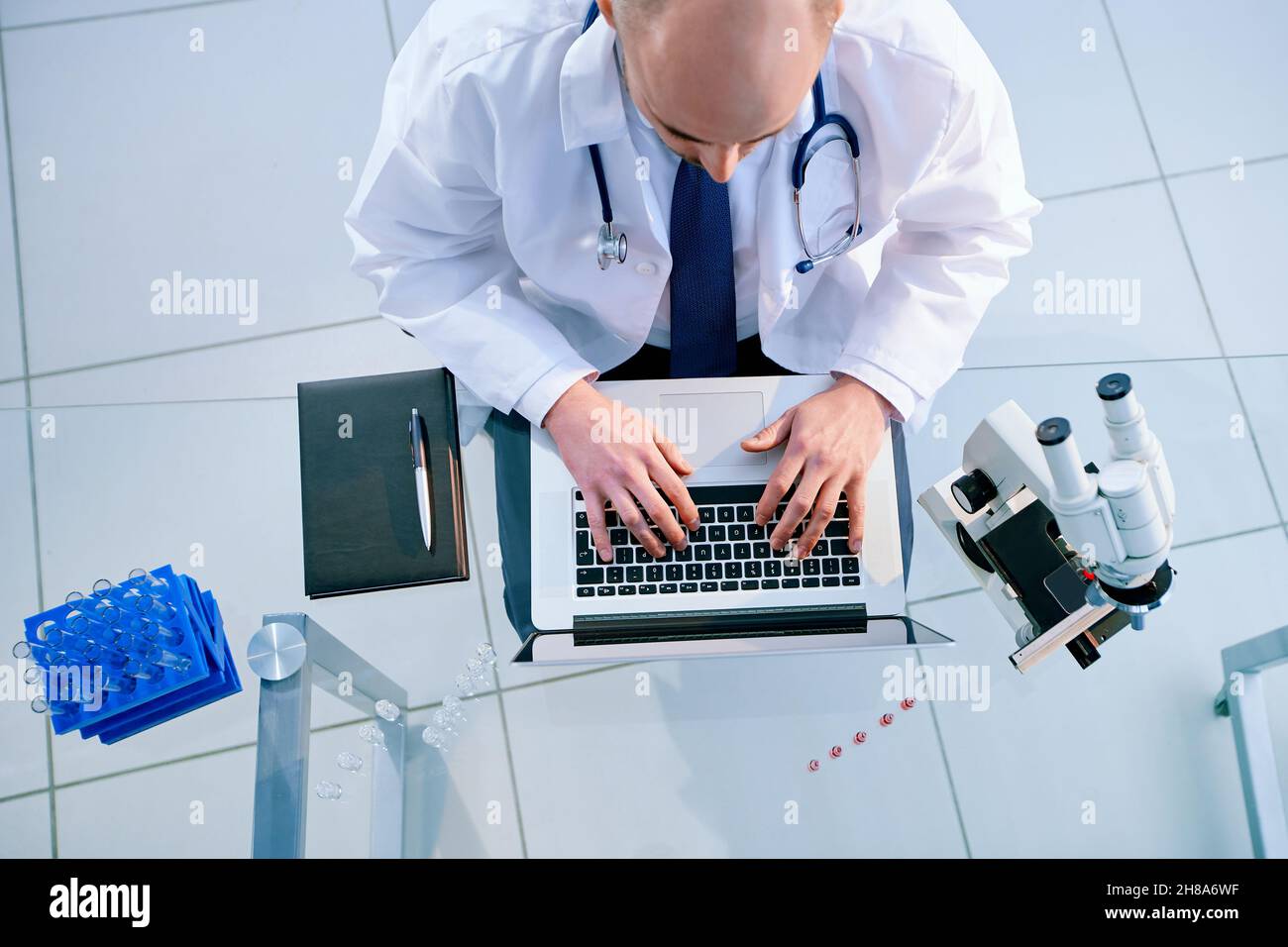 top view. science lab technician using a laptop during his research ...
