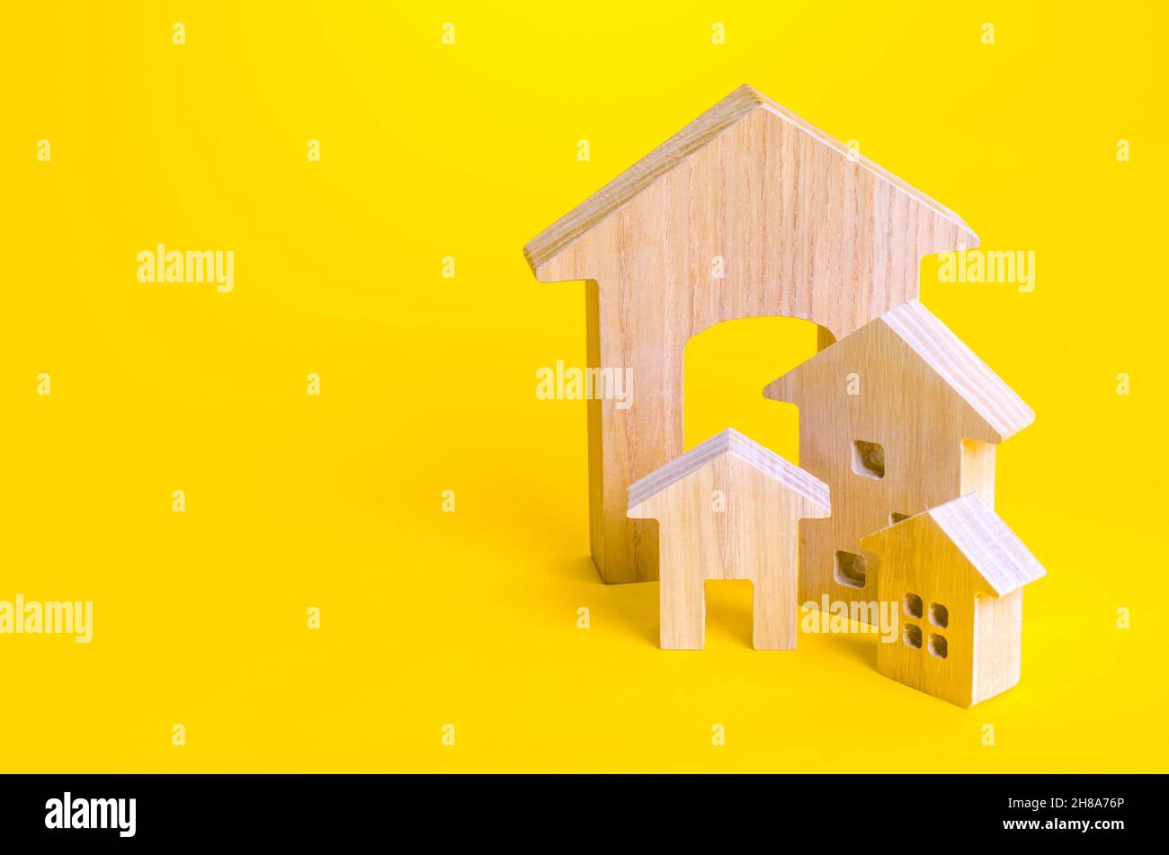 Figures of residential buildings on a yellow background. Affordable housing. Search best option apartment and real estate, rent. Purchase of housing. Stock Photo