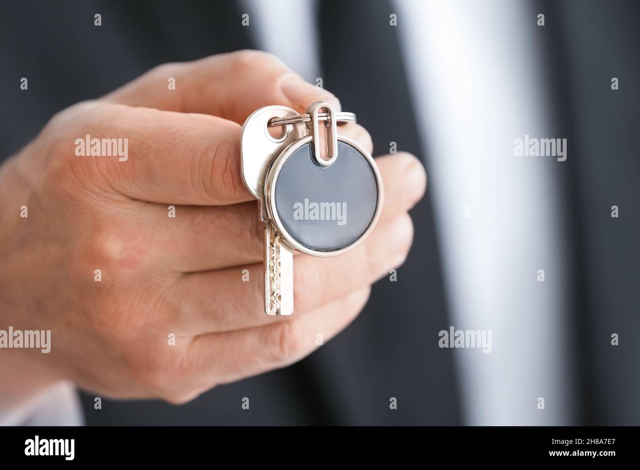 Man holding key on chain, closeup Stock Photo