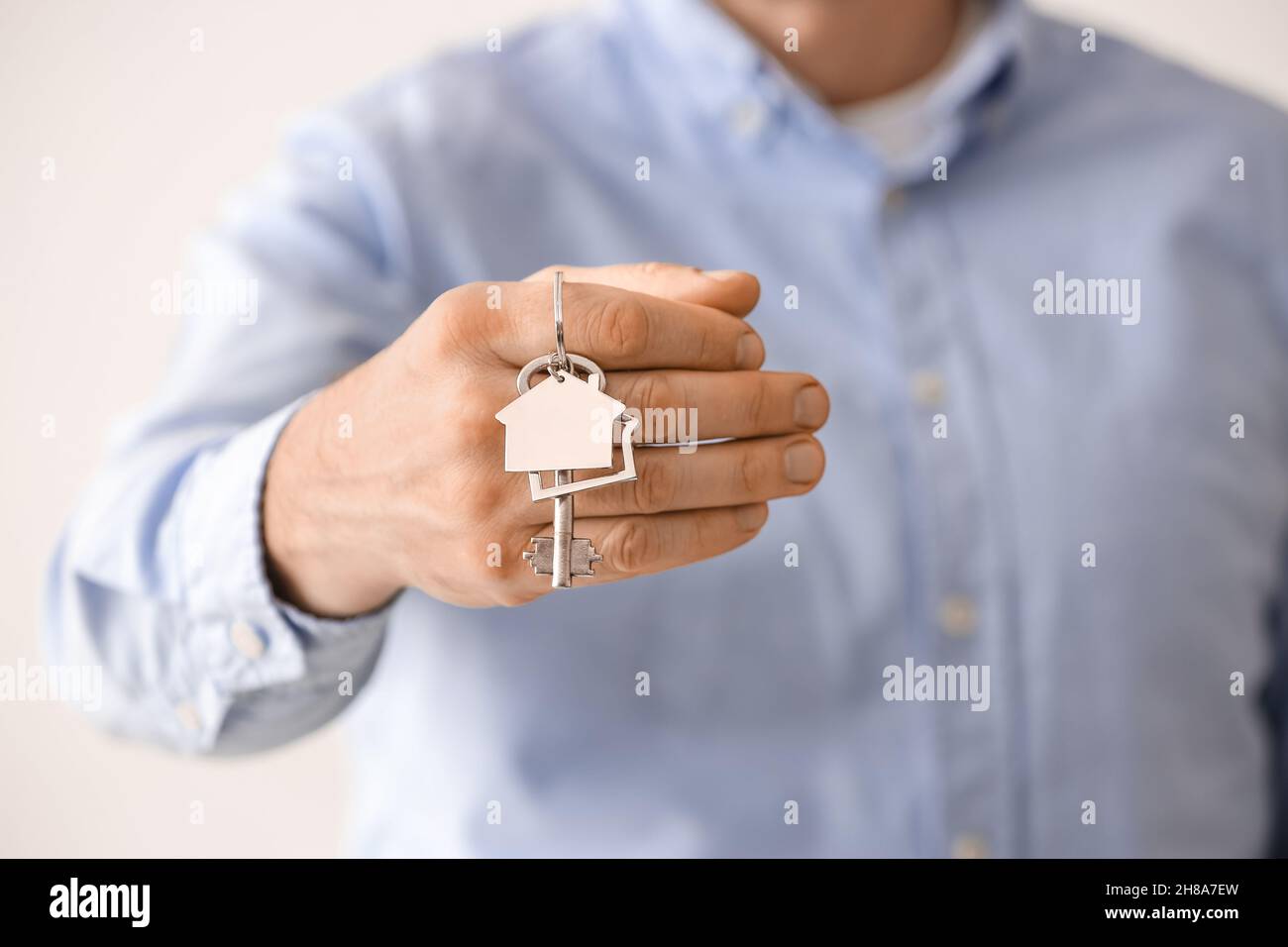 Man holding key from house, closeup Stock Photo