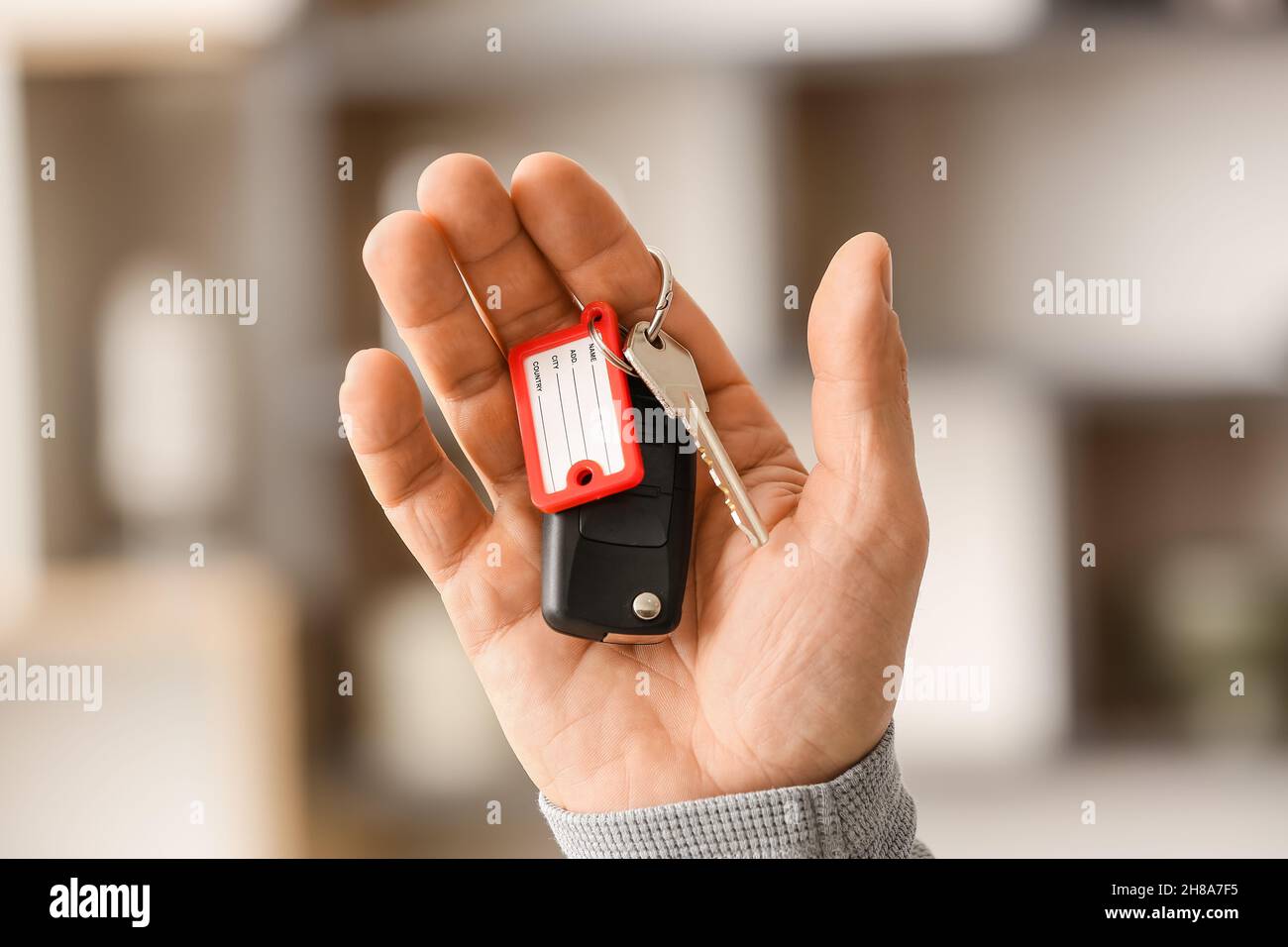 Male hand holding keys on chain Stock Photo - Alamy