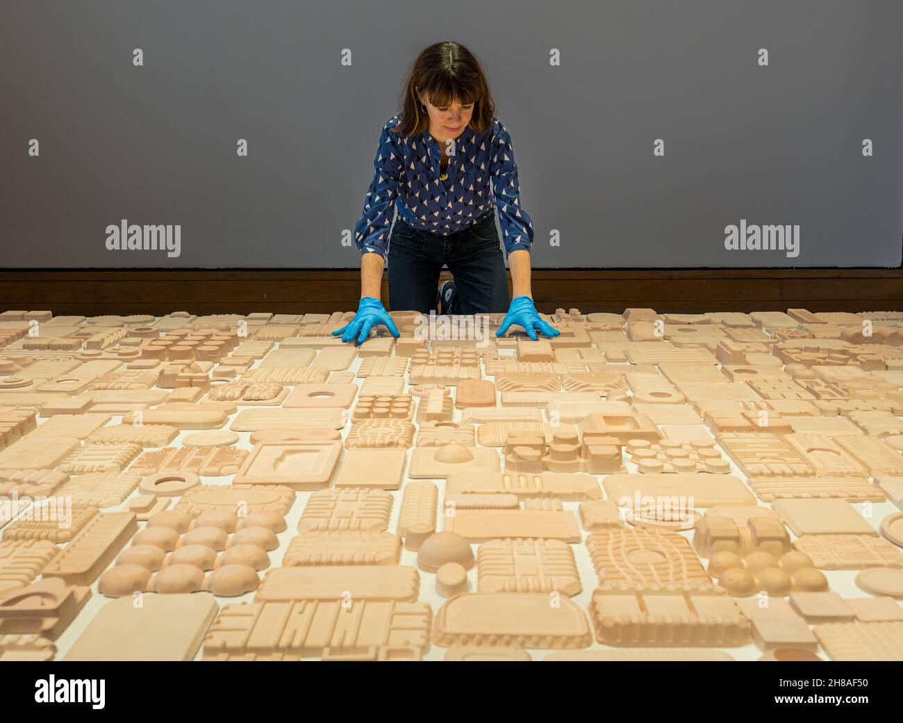 Curator with artwork by Henny Burnett made from moulds of packaging in tapestry art exhibition , City Art Centre, Edinburgh, Scotland, UK Stock Photo