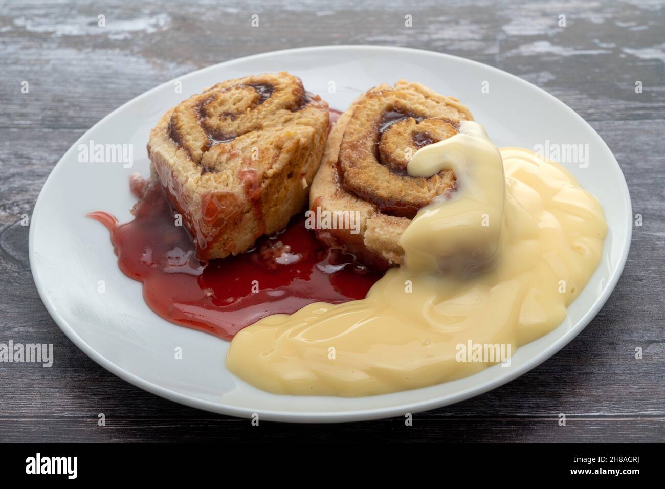 Hot jam roly poly and custard dessert Stock Photo