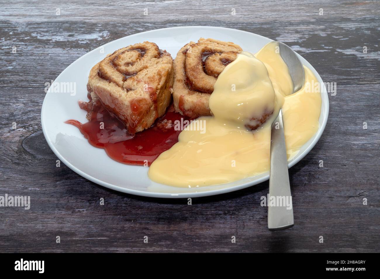 Hot jam roly poly and custard dessert Stock Photo Alamy