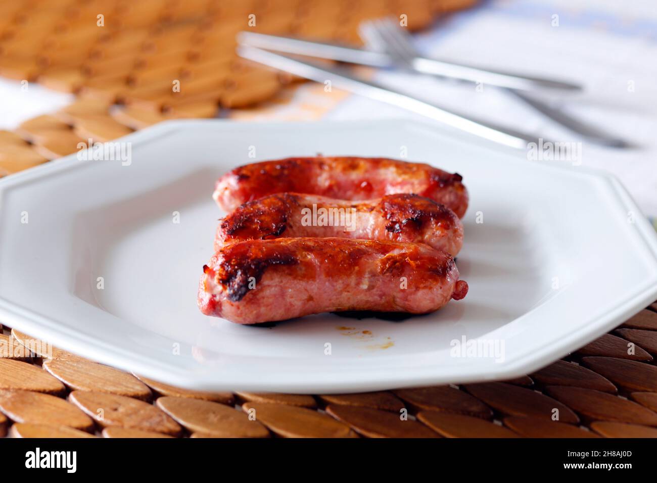 roasted sausage in white dish on the table Stock Photo