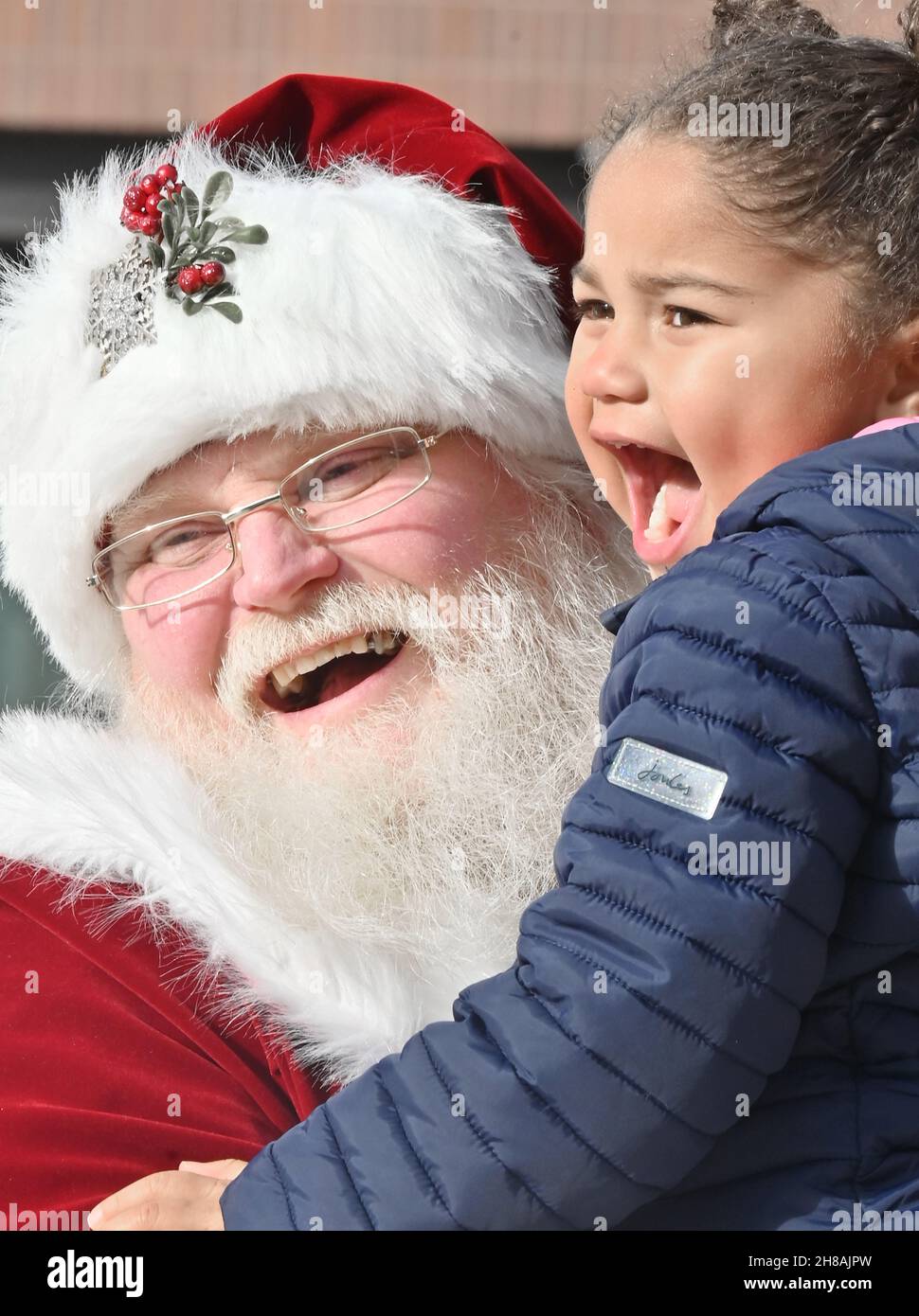 Wilkes Barre, United States. 27th Nov, 2021. A man portraying Santa Claus laughs with a young girl during a holiday market.A man portrays Santa Claus at a holiday marketplace and interacts with children as the kick off of the Christmas season on Small Business Saturday. Credit: SOPA Images Limited/Alamy Live News Stock Photo