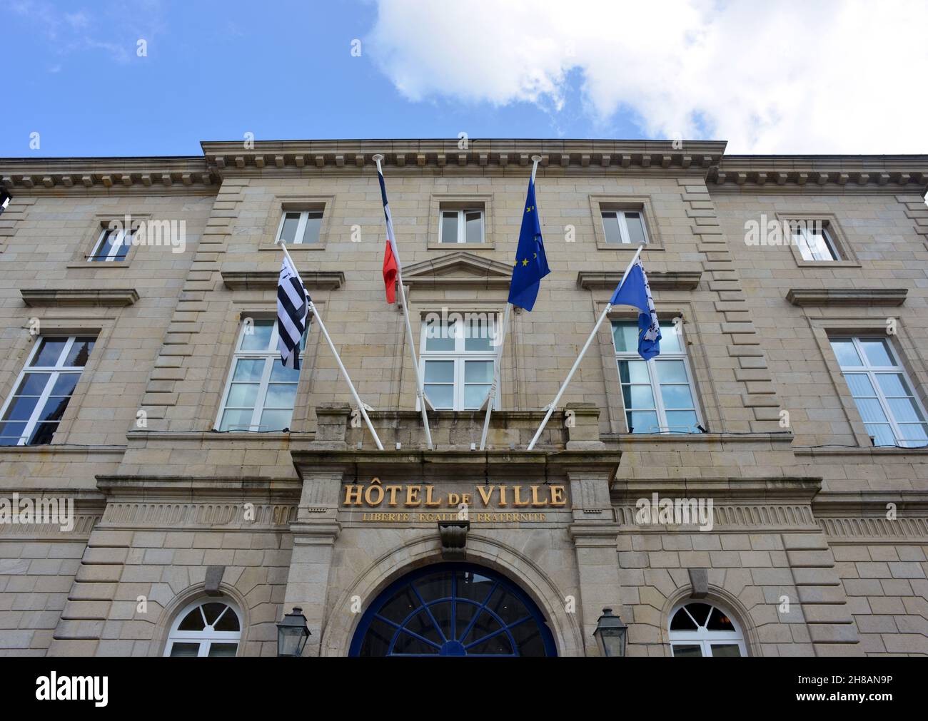 Quimper, France 08-10-2021 town hall with flags and blue sky Stock Photo