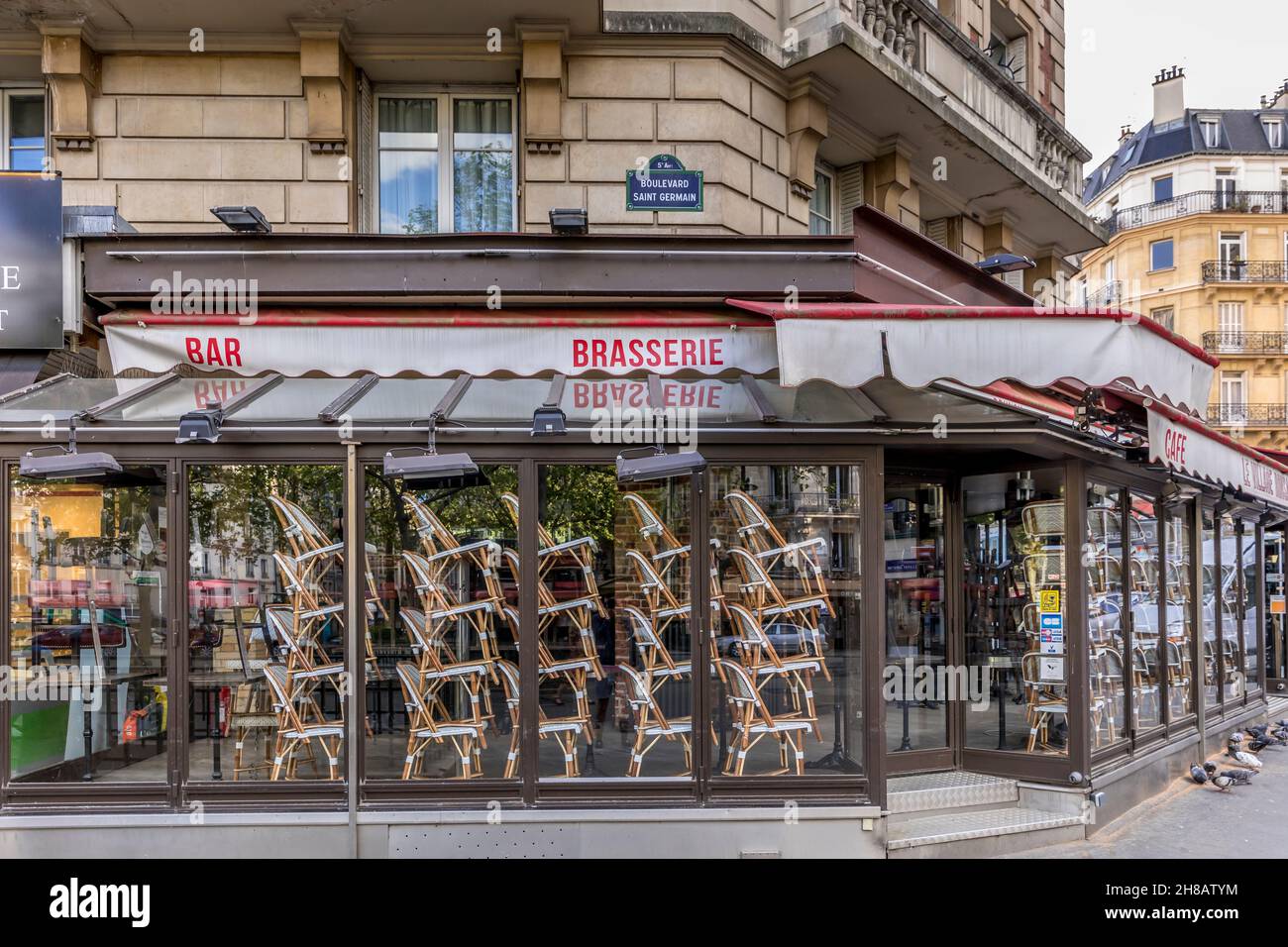 Paris, France - April 17, 2020: Restaurant brasserie on Boulevard Saint Germain is closed due to epidemic of coronavirus COVID19 in Paris. Empty bar, Stock Photo