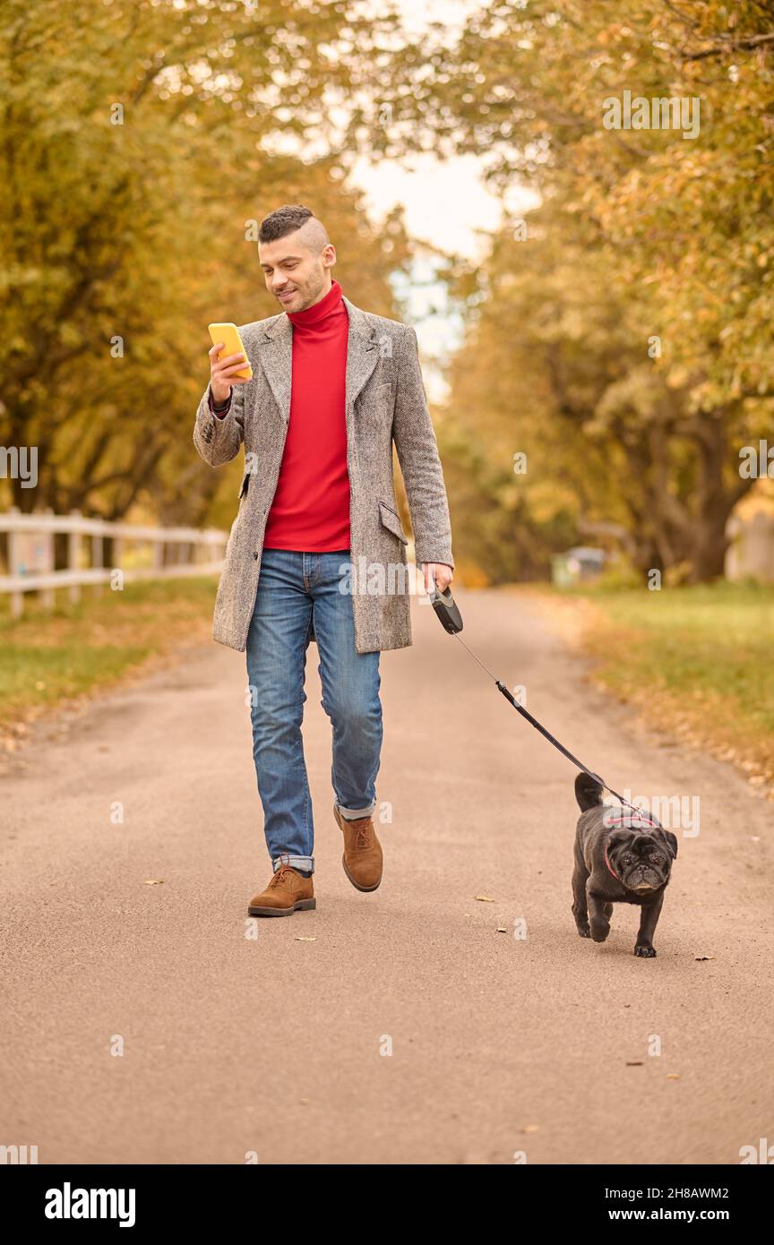 Man walking with a dog in a park Stock Photo - Alamy