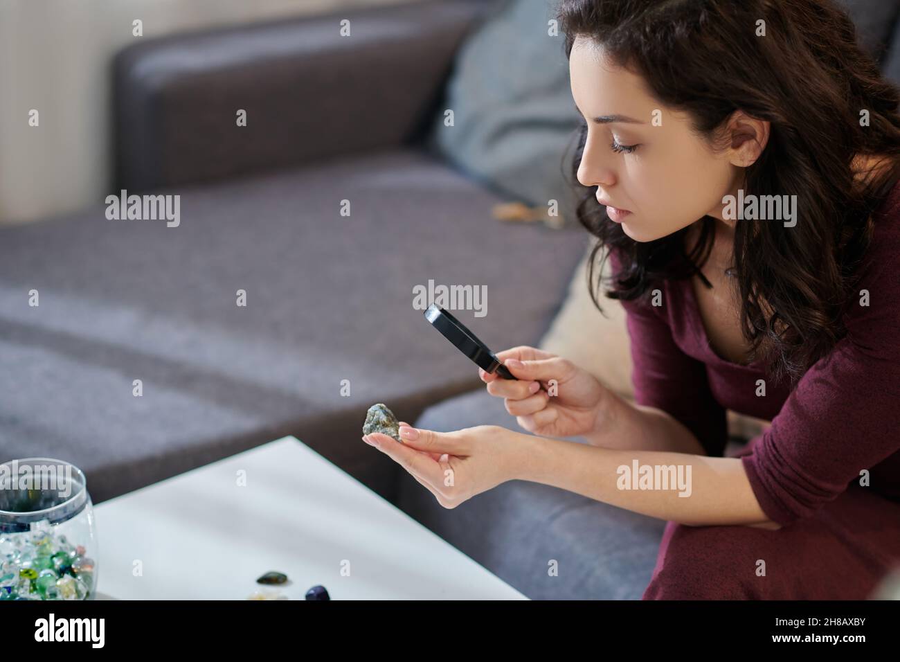 Pretty lady scrutinizing the mineral in her hand Stock Photo