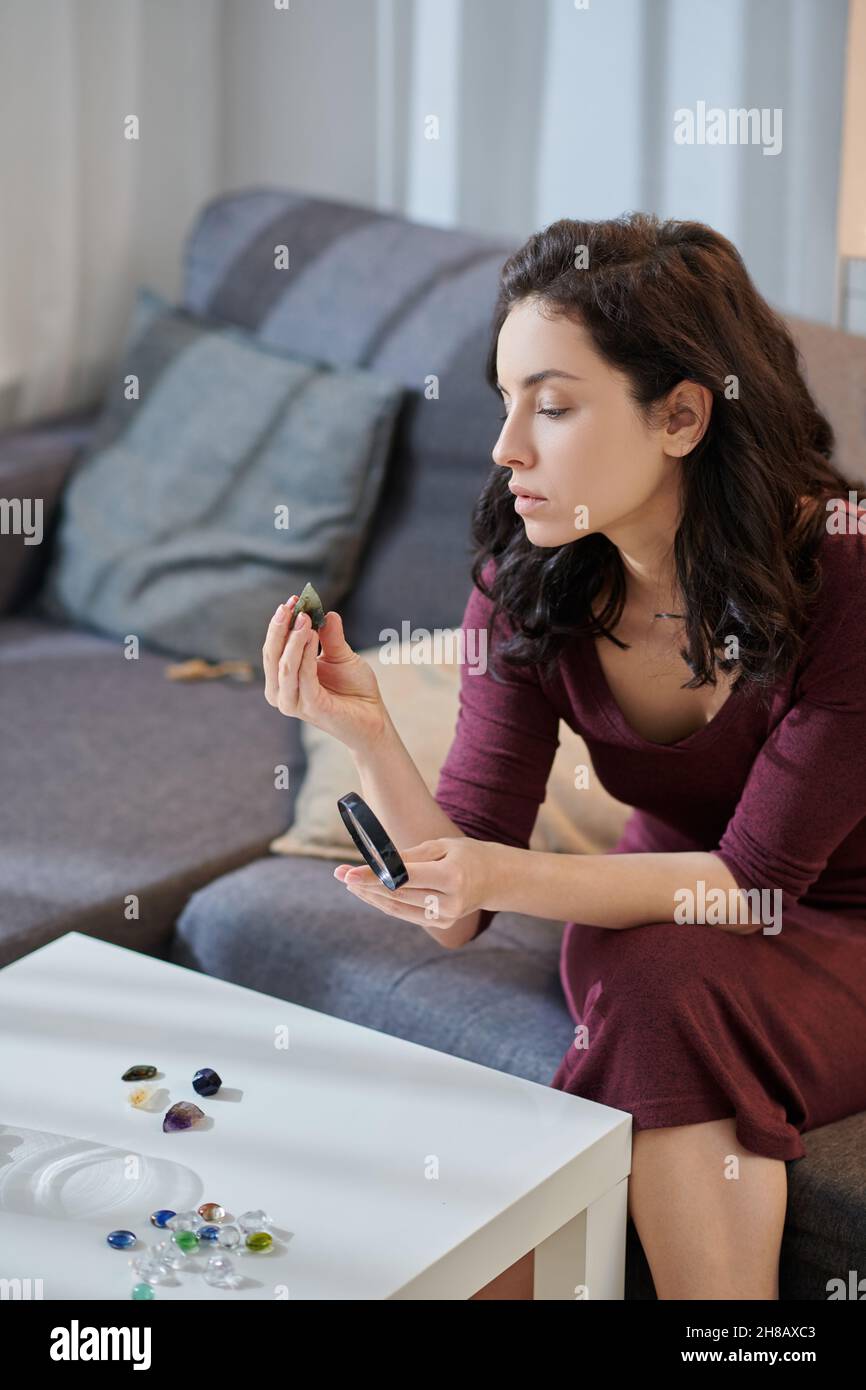 Beautiful woman staring at stone in her hand Stock Photo