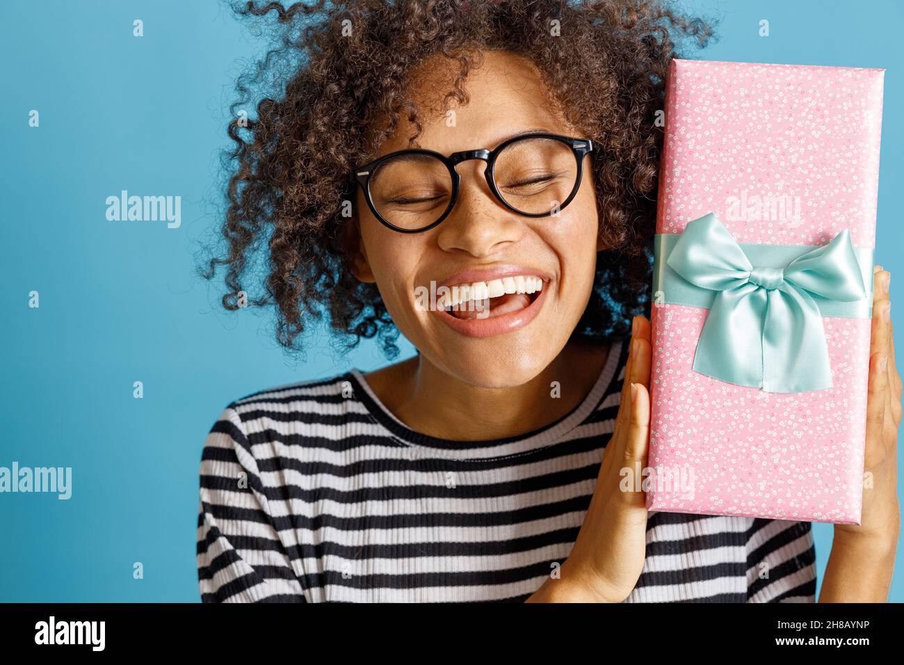 Happy joyful woman holding gift box with ribbon Stock Photo