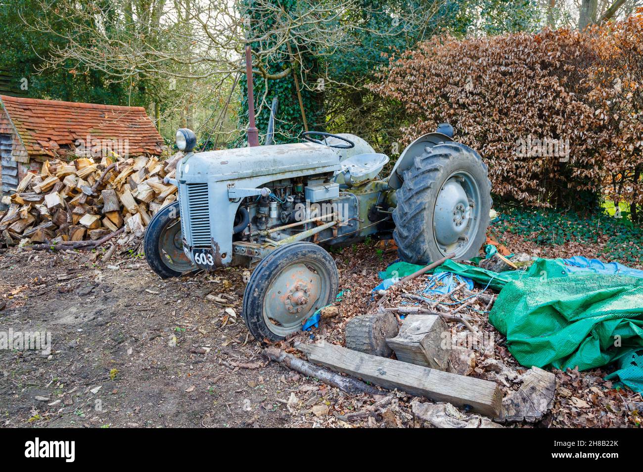 A broken down and dilapidated vintage, grey, old-fashioned traditional design tractor left to rust, decay and fall apart; Surrey, south-east England Stock Photo
