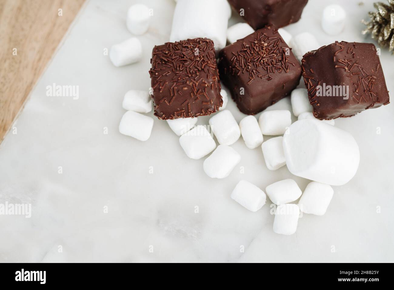Dark Chocolate Petit Fours on White Background with Marshmallows, Copy Space Stock Photo