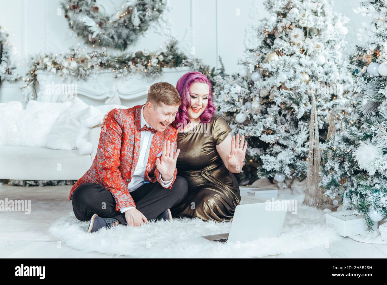 LGBTQ lesbian homosexual couple celebrating Christmas or New Year. Gay young lady female woman with butch partner calling friends and family online on Stock Photo