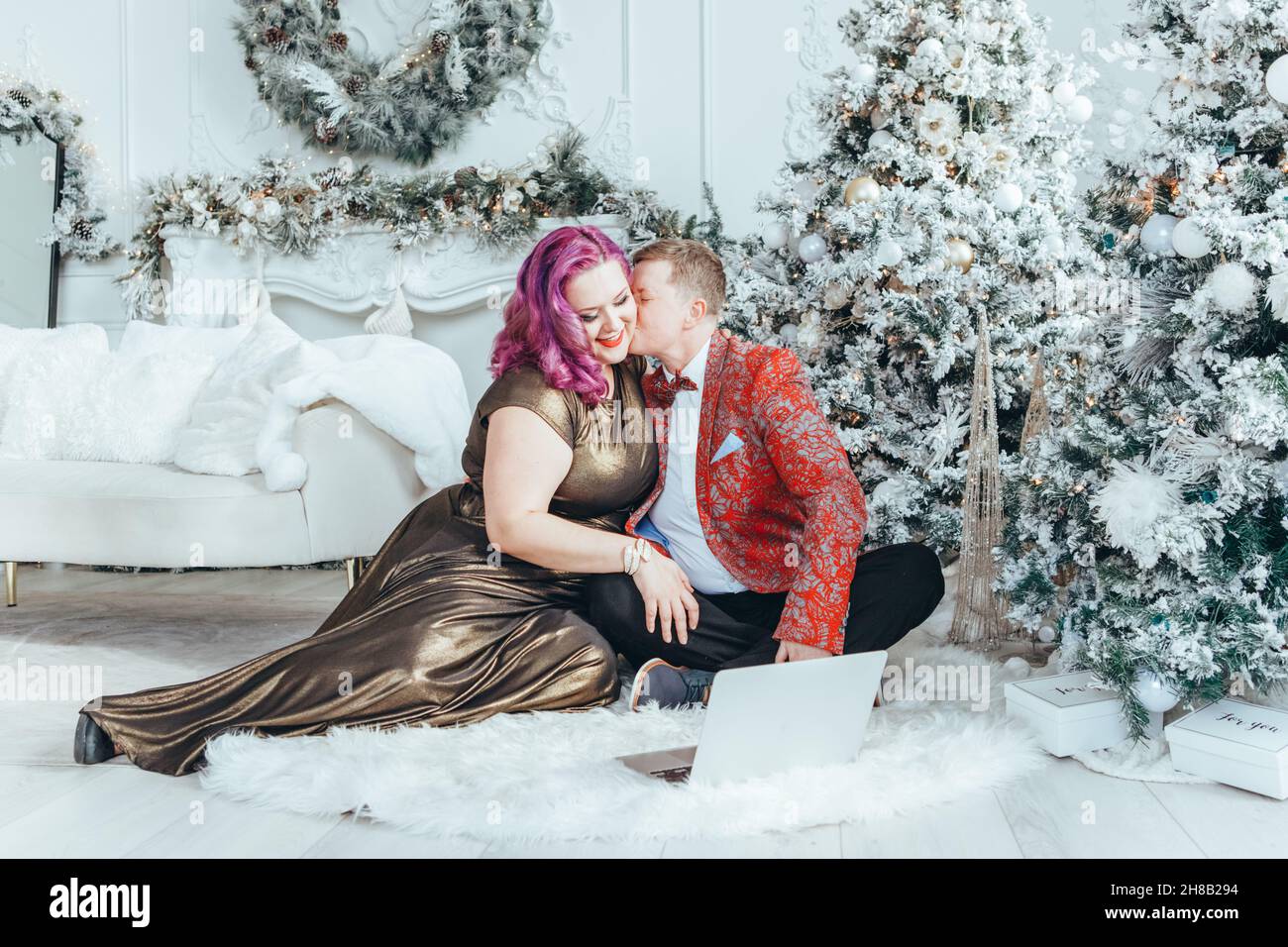 LGBTQ lesbian homosexual couple celebrating Christmas or New Year. Gay young lady female woman with butch partner calling friends and family online on Stock Photo