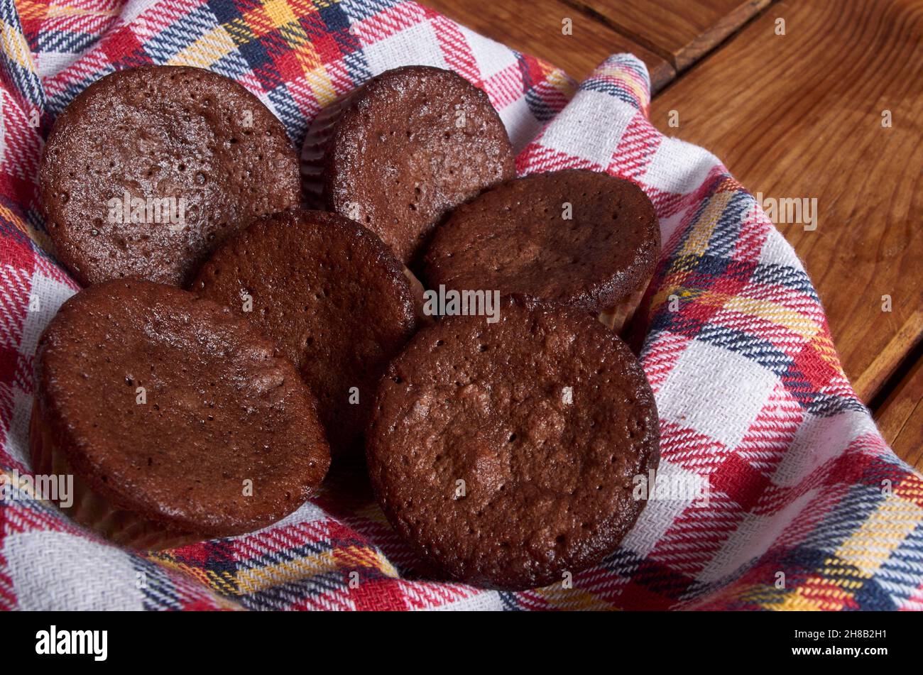 Delicious chocolate cupcakes with baking cloth on wood table Stock Photo