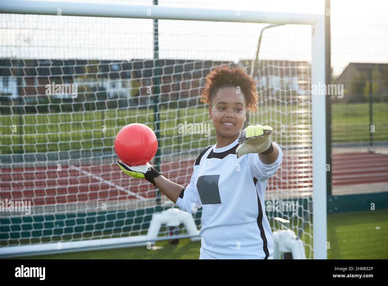 UK, Smiling female soccer goalie throwing ball Stock Photo Alamy