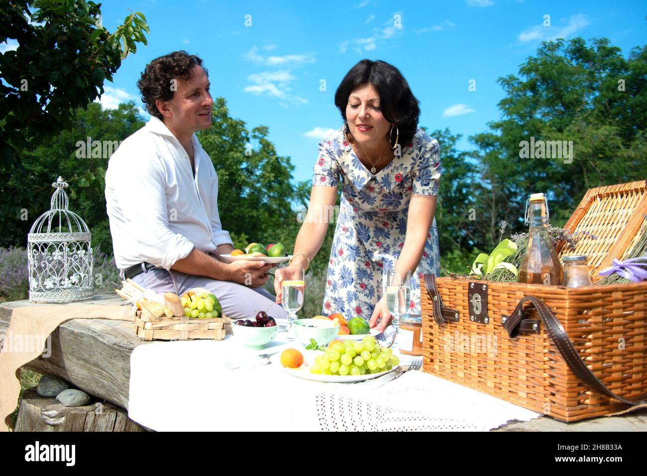 Smiling mature couple enjoying picnic in landscape Stock Photo