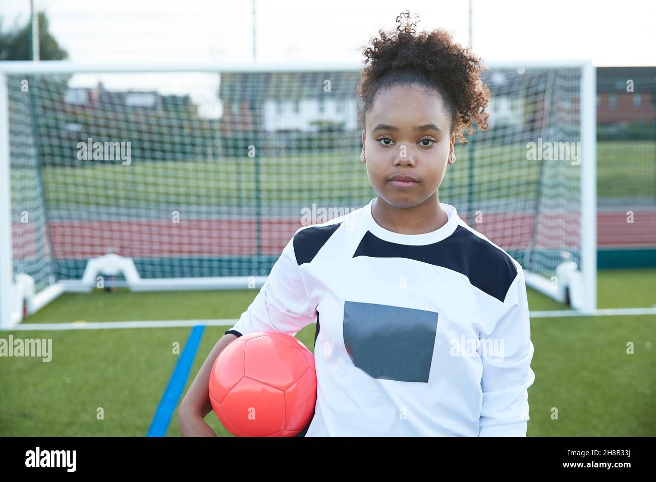 UK, Portrait of female soccer player (12-13) in front of goal Stock Photo