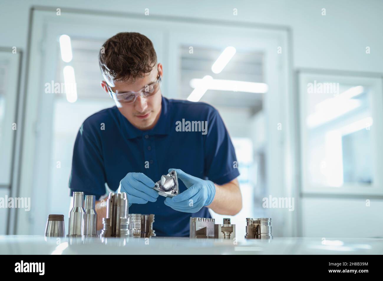 Man holding metal 3d printed objects in laboratory Stock Photo