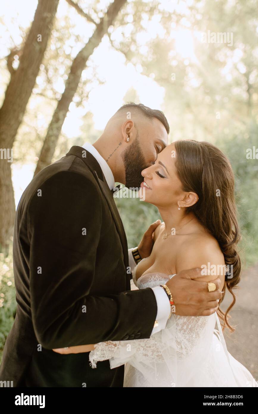 Bride and groom kissing in park Stock Photo - Alamy