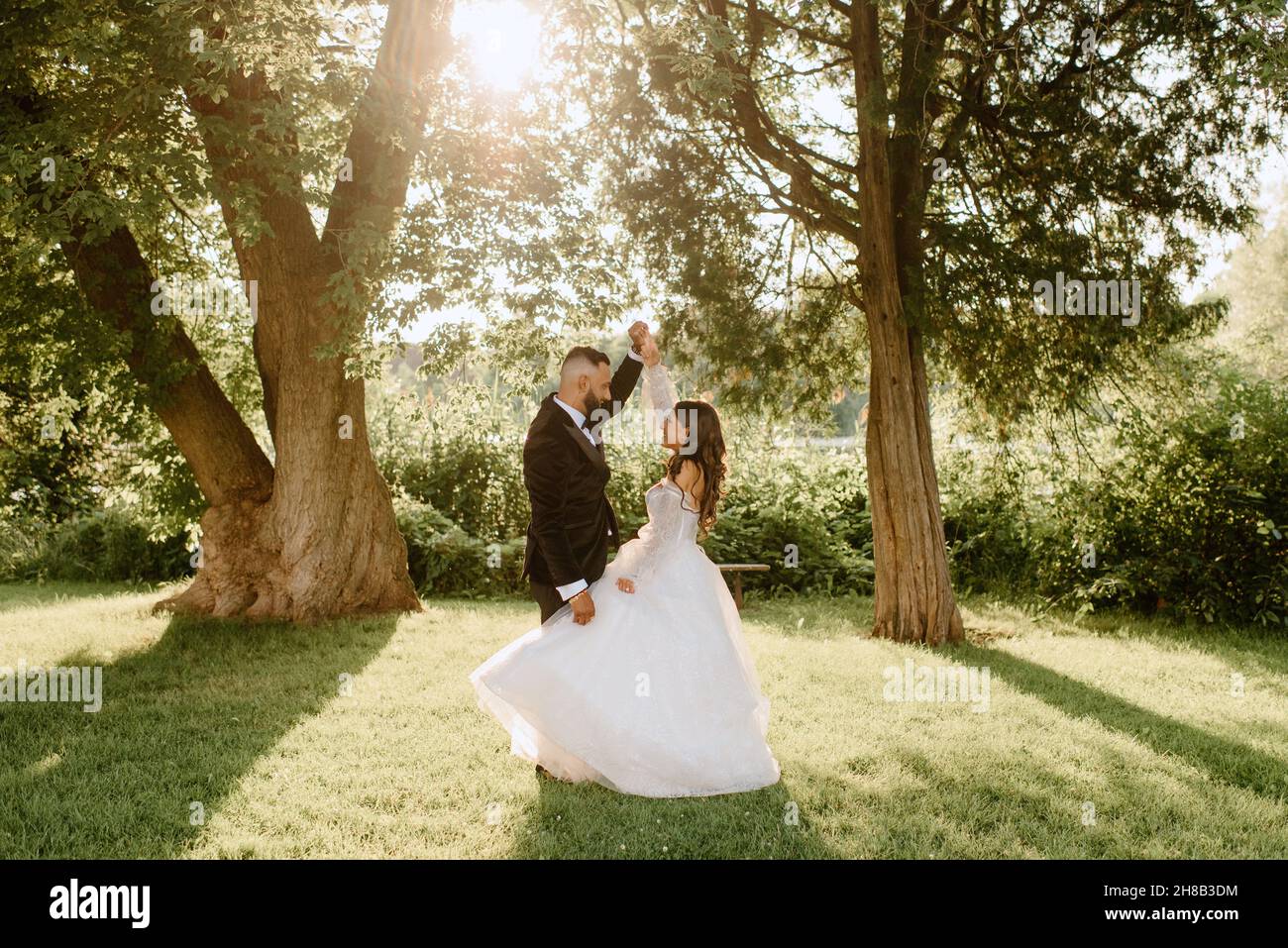 Bride and groom holding hands in park Stock Photo - Alamy
