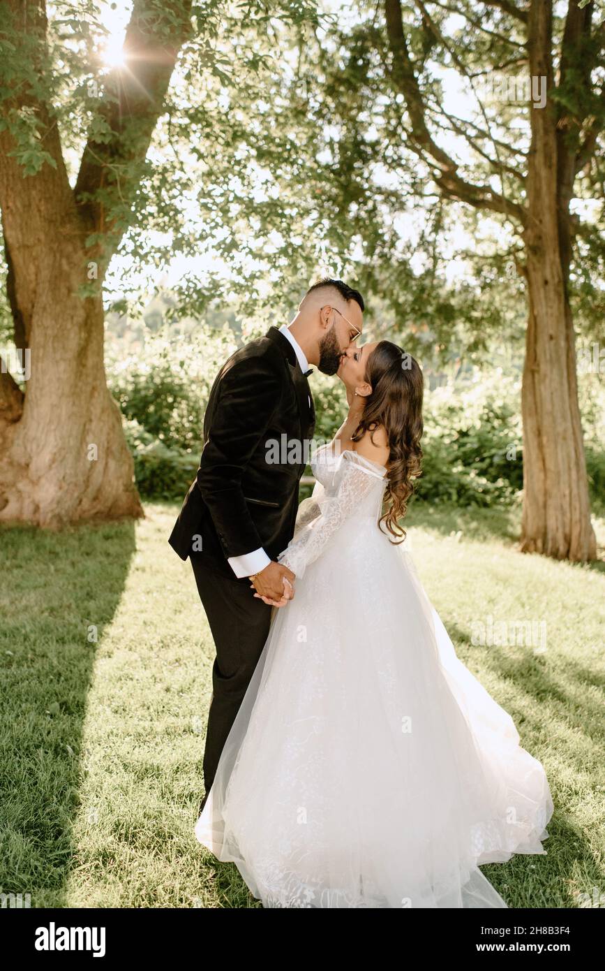 Bride and groom kissing in park Stock Photo - Alamy