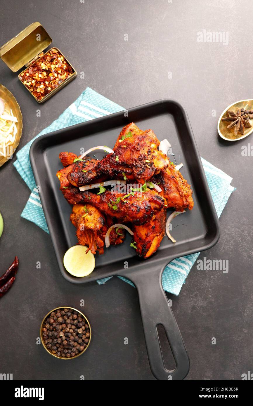 Tandoori chicken is a popular roast chicken recipe from India. Tandoor is a  traditional wood oven. Chicken Tandoori Platter is served in a black plate  Stock Photo - Alamy