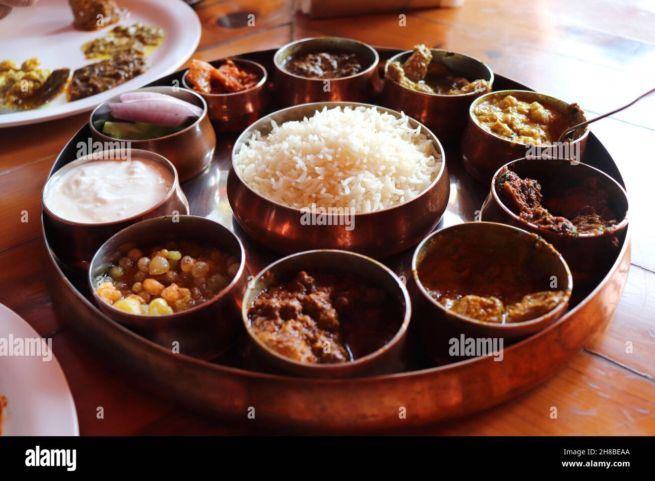 Dham - Traditional food of Himachal Pradesh. Himachali kangri dham thali includes Kaddu ka khatta, Chane ka Madra, sepu vadi, maash dal, Rajma, salad. Stock Photo