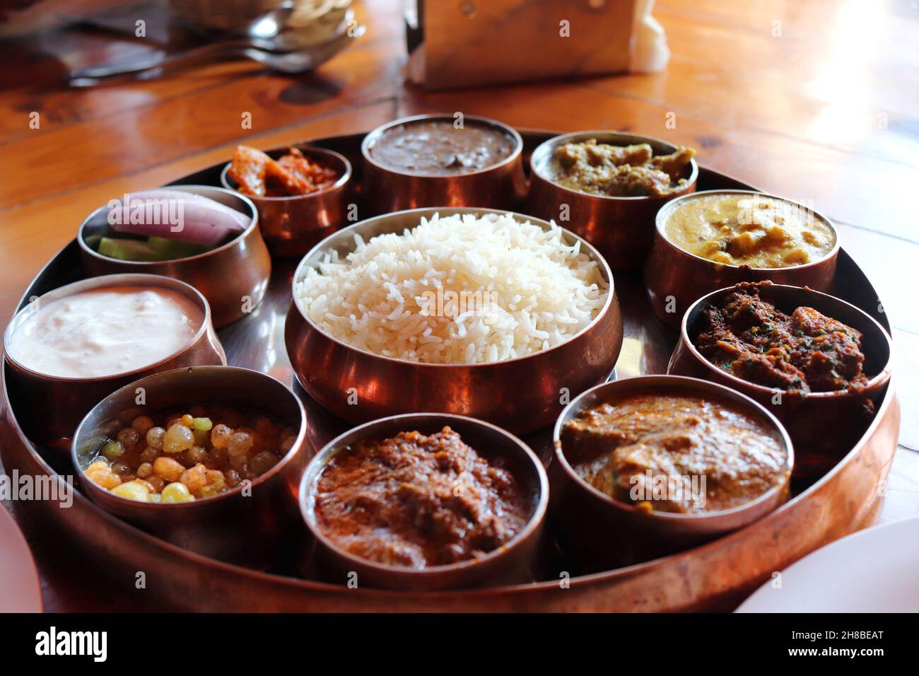 Dham - Traditional food of Himachal Pradesh. Himachali kangri dham thali includes Kaddu ka khatta, Chane ka Madra, sepu vadi, maash dal, Rajma, salad. Stock Photo