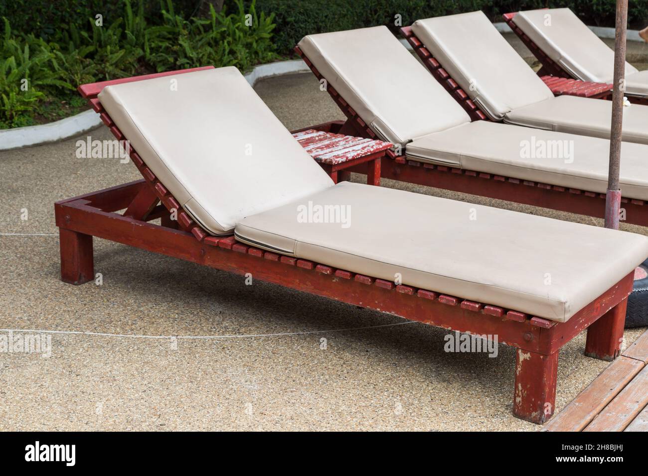 Pool chair side of swimming pool background Stock Photo - Alamy