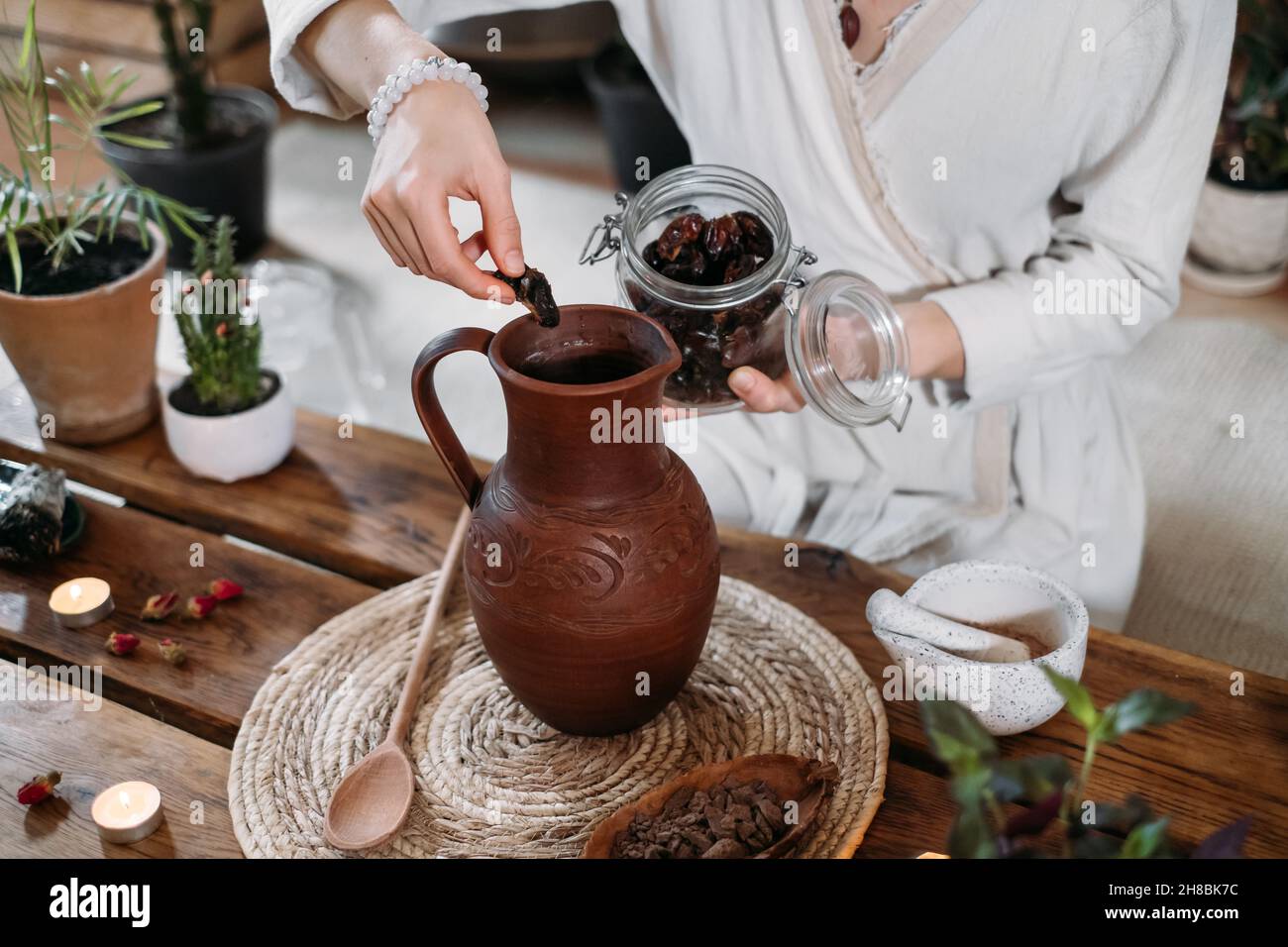 Cocoa Personal Ritual Cacao ceremony in atmospheric space with green plants and candles ...