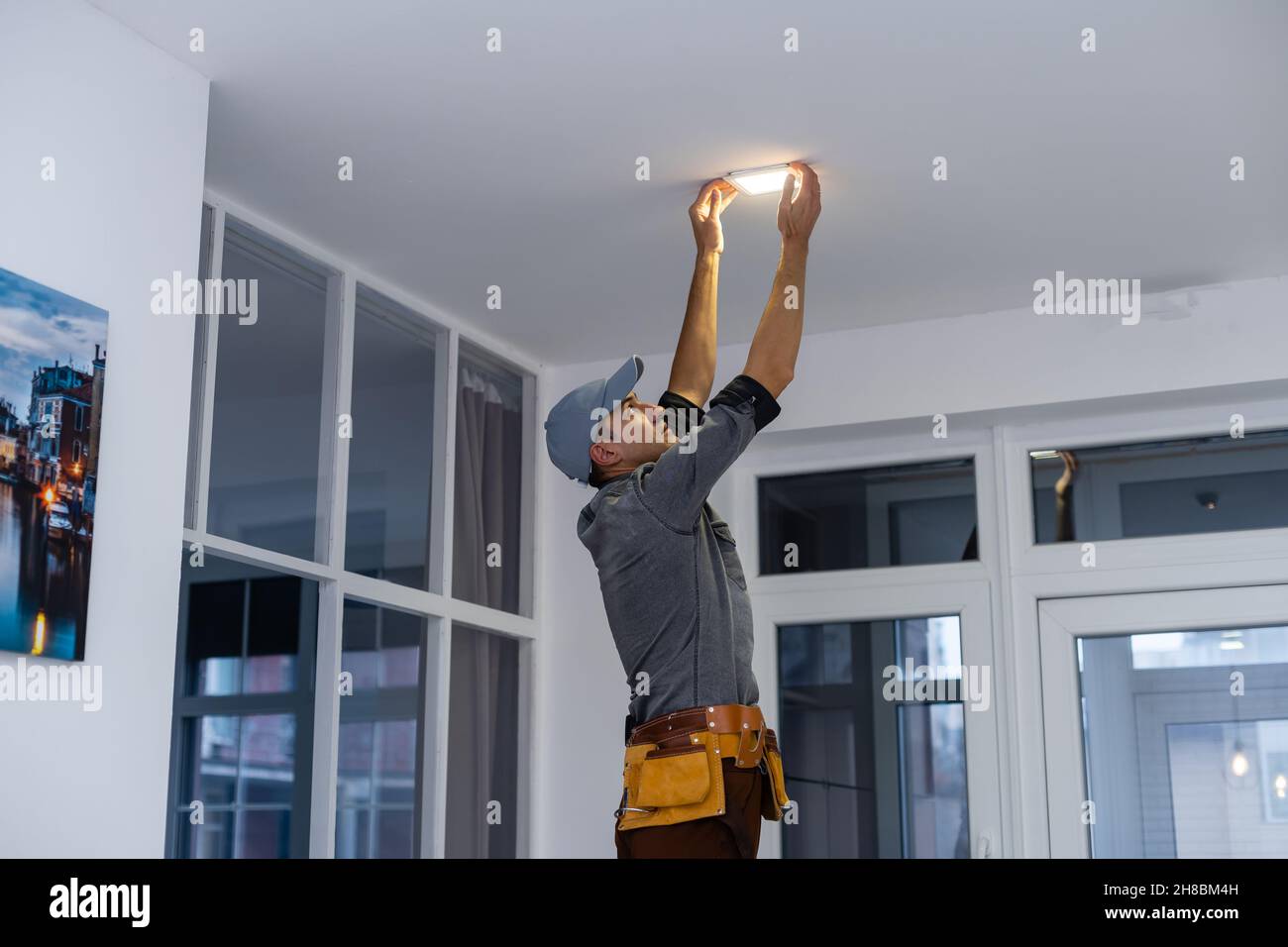 An electrician is installing spotlights on the ceiling Stock Photo - Alamy