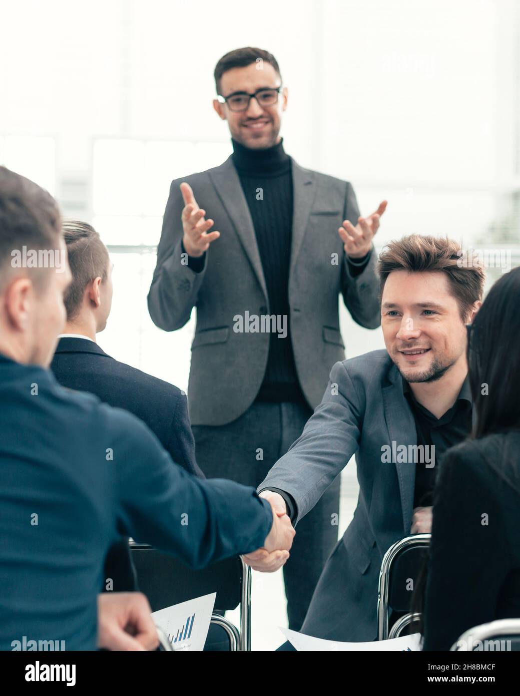 smiling employees shaking hands during a working meeting Stock Photo