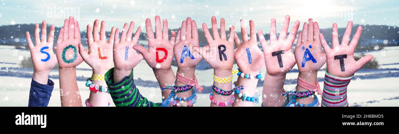 Kids Hands Holding Word Solidaritaet Means Solidarity, Snowy Winter Background Stock Photo
