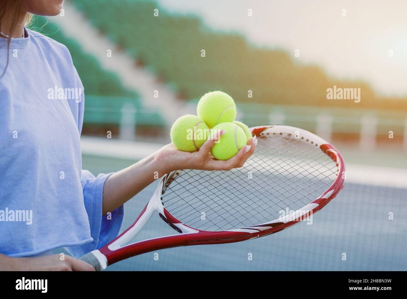 female hands holding tennis racket and three balls Stock Photo Alamy