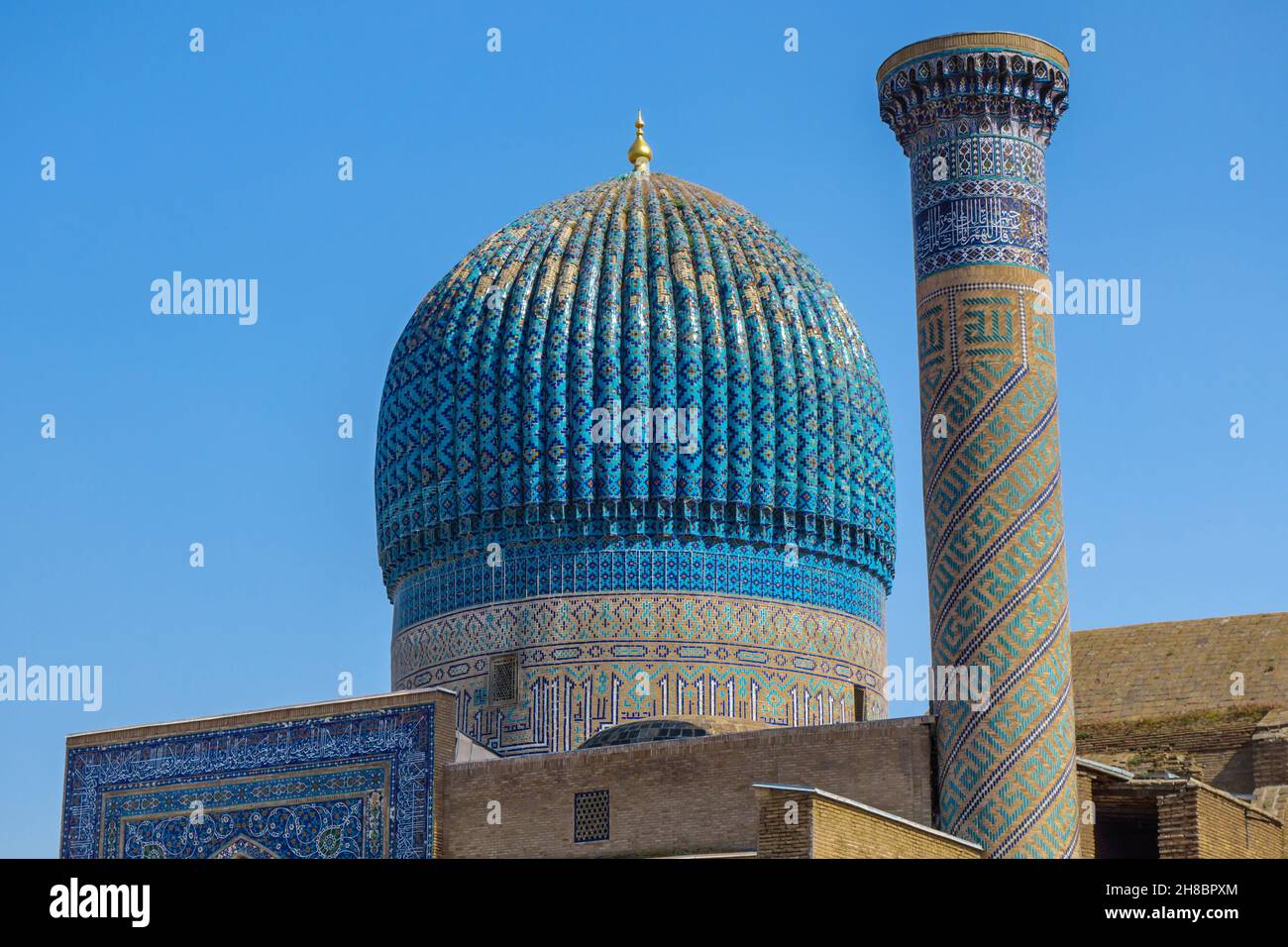 Close up view onto main dome of mausoleum Gur-e-Amir, Samarkand, Uzbekistan. Also there are minaret and upper part of entrance portal Stock Photo