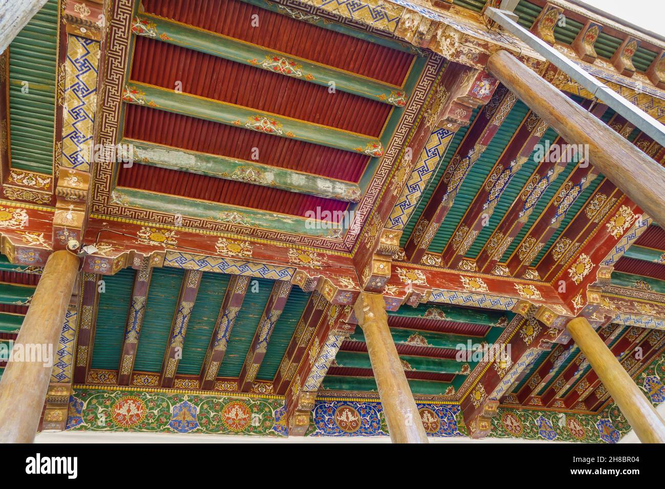 Colorful ornaments on wooden ceiling of street gallery (or iwan) of Ruhabad mosque. Shot in Samarkand, Uzbekistan Stock Photo