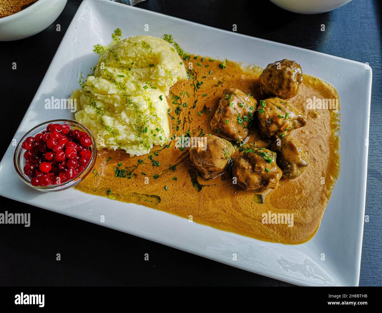 Swedish typical dish consisting of meatballs with sauce, mashed potatoes and ribes. Tasty recipe with Swedish meat balls floating on a thick gravy Stock Photo