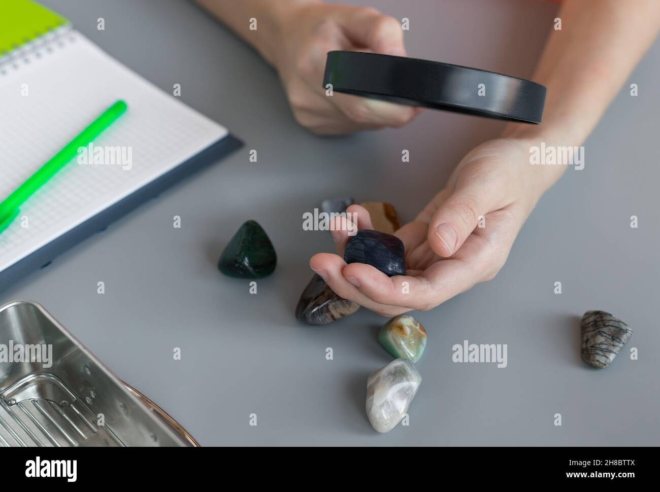 boy studying semiprecious stones with magnifying glass at lesson Stock