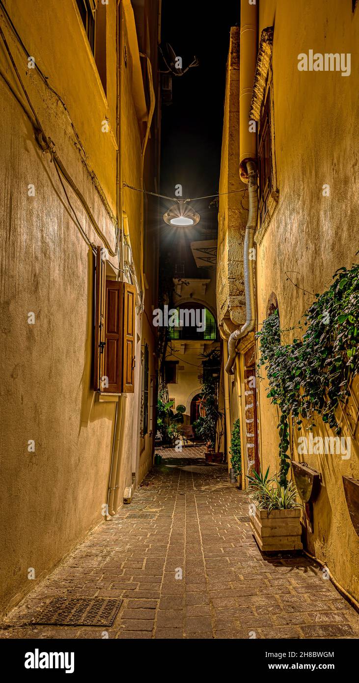 The narrow alley Antoniou Gampa at night in the old town of Chania, illuminated with a lamp hanging over the street, Chania, Crete, Greece, October 13 Stock Photo