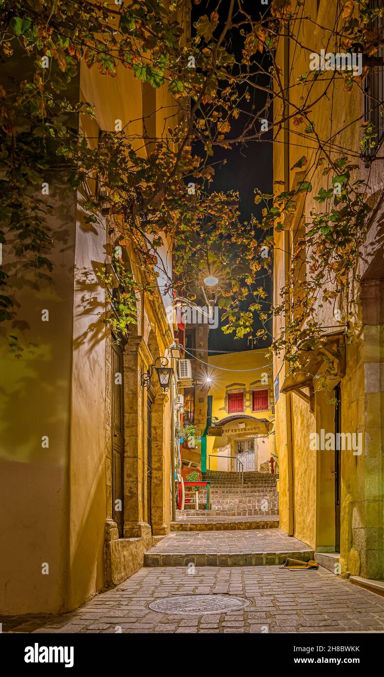 the romantic stairs of the Zampeliou alley in the old town of Chania, lit by a lantern above the foliage, Crete, Greece, October 13, 2021 Stock Photo