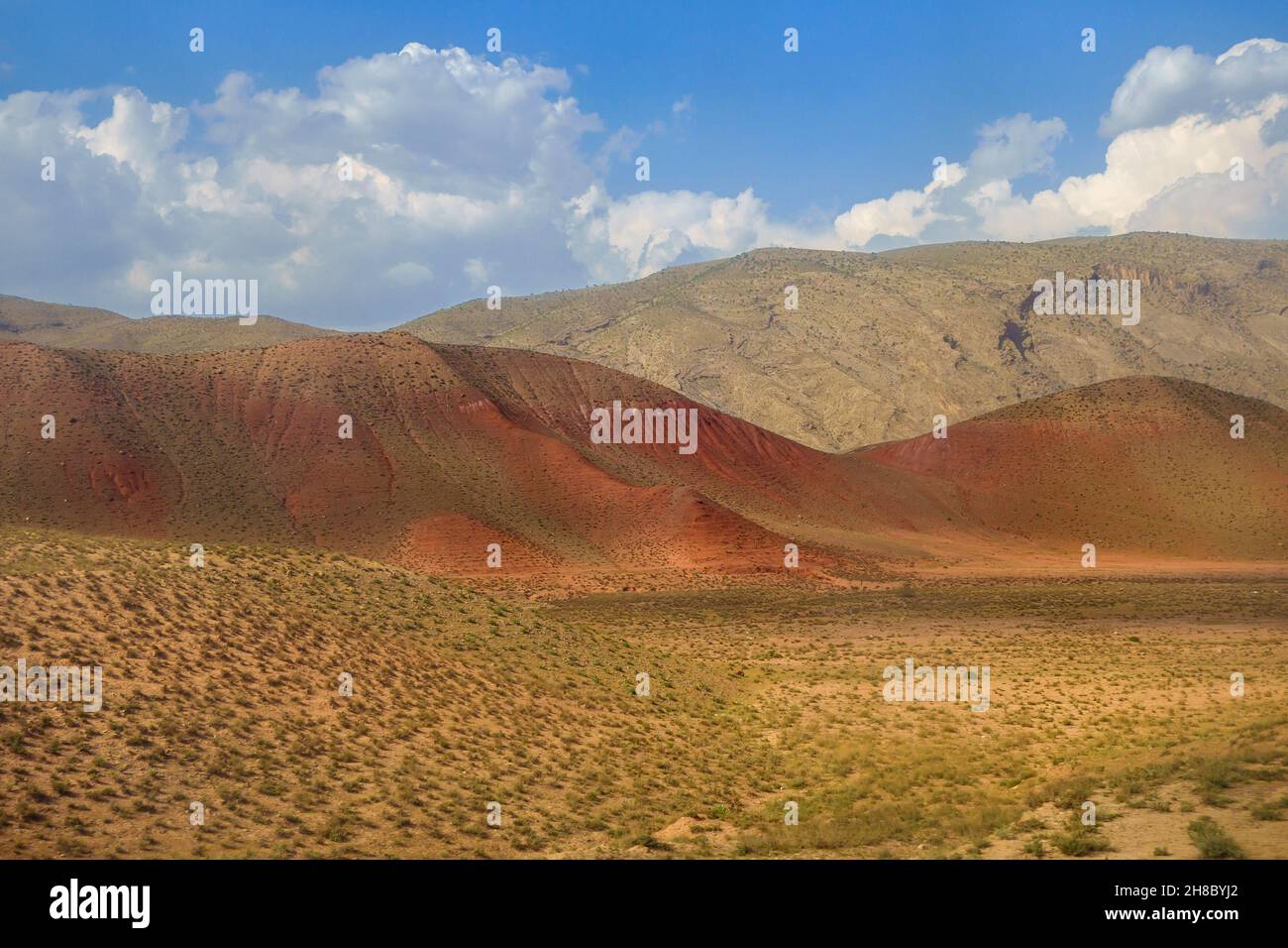Valley at the foot of Gissar range with hills of unusual reddish color. Shot in the Surkhandarya region in the south of Uzbekistan Stock Photo