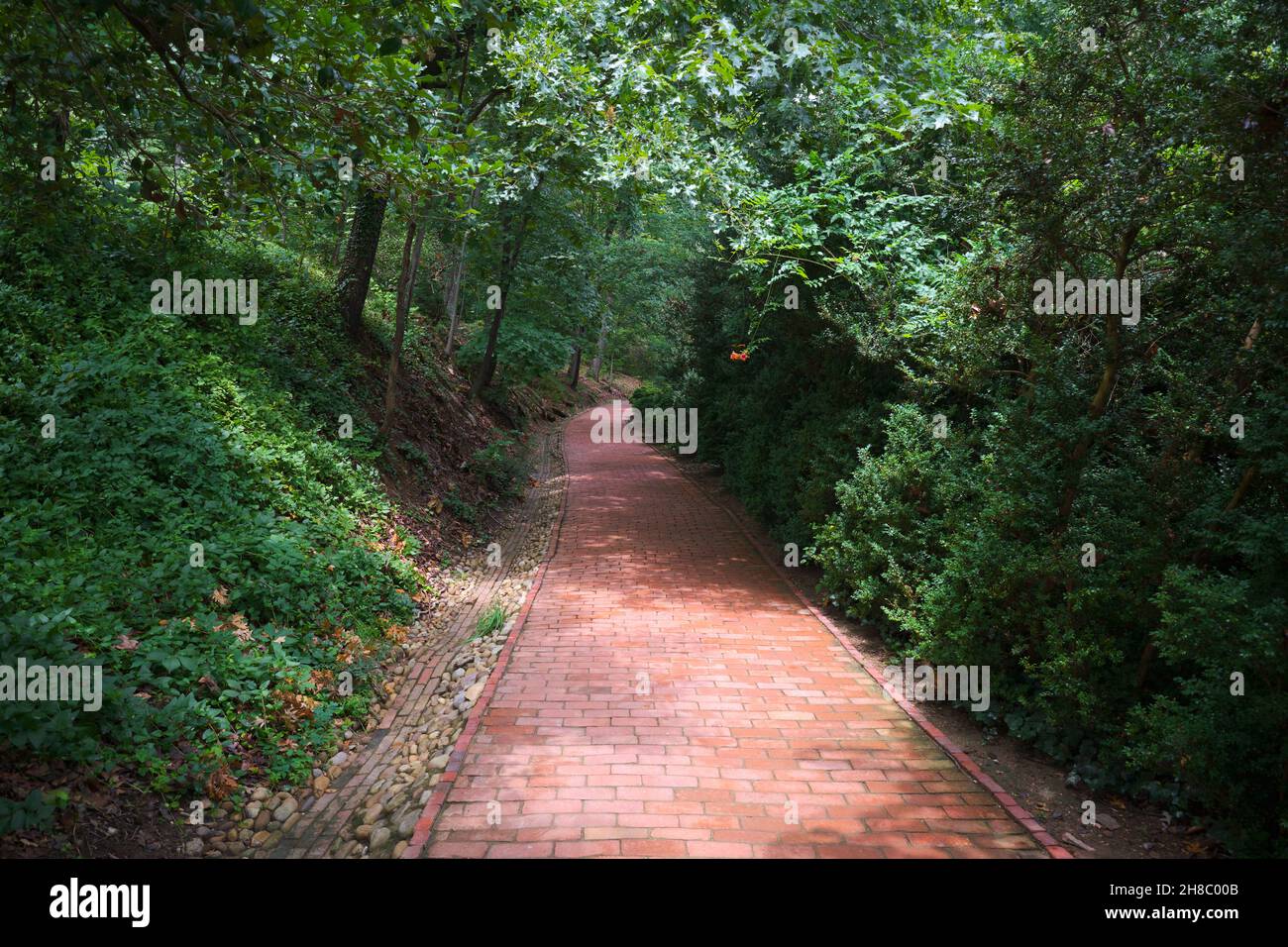 One of the nice, quiet, shaded red brick cobblestone paths, trails on the property. At President George Washington's estate home, Mount Vernon, in Vir Stock Photo