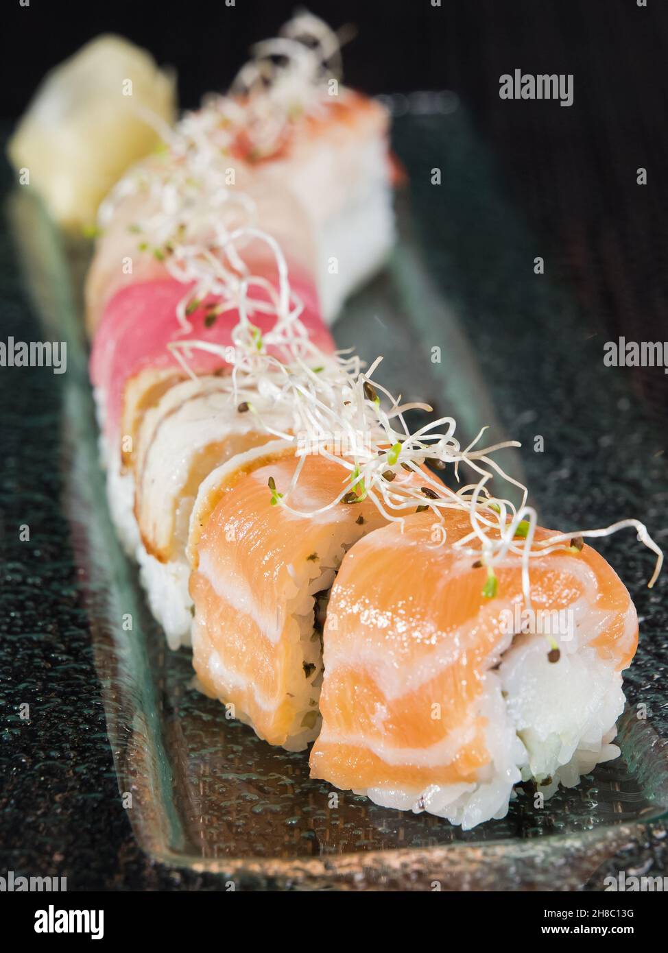 sushi roll with salmon, tuna and eel on a glass plate, close up photo