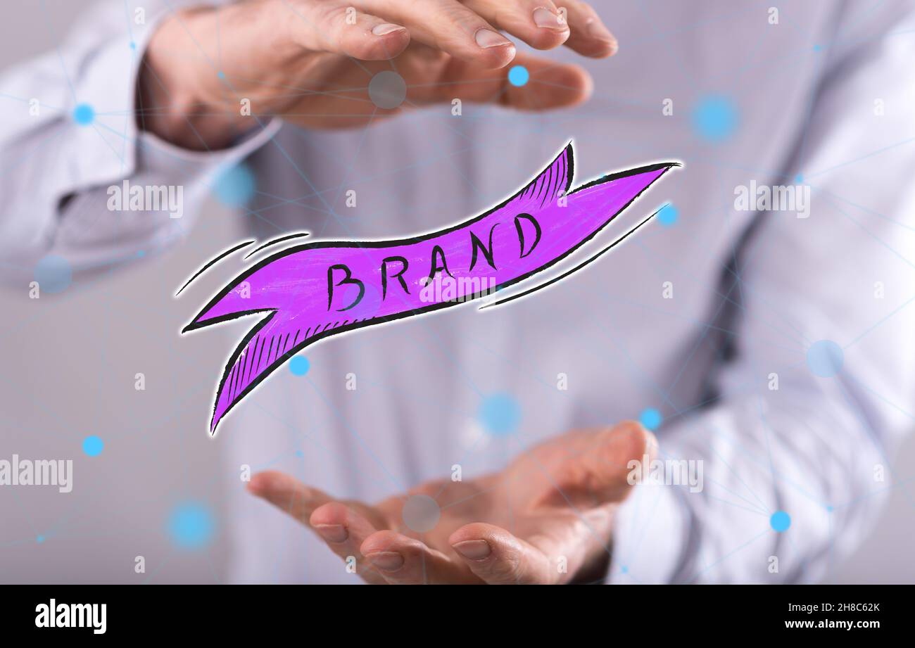 Brand concept between hands of a man in background Stock Photo - Alamy