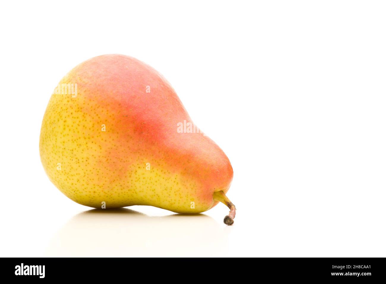 Single red yellow pear lying sideways on white background Stock Photo