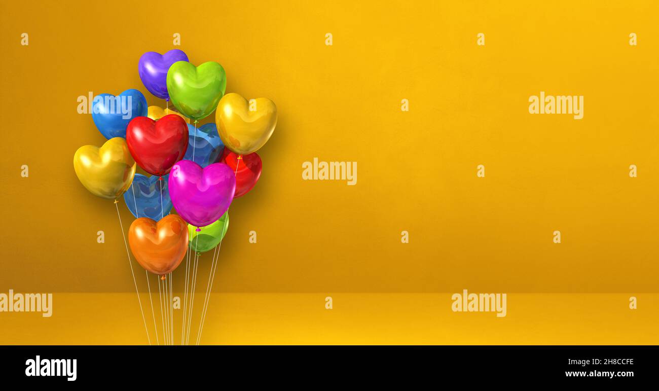 Colorful heart shape balloons bunch on a yellow wall background ...